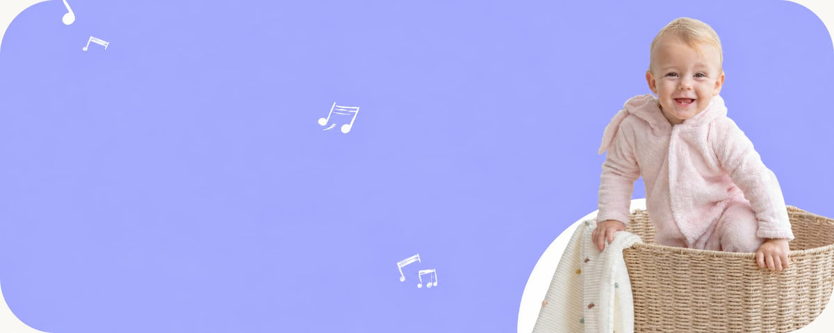 A baby wearing a light pink long-sleeve romper sits in a woven basket against a solid lavender background with floating white musical notes.